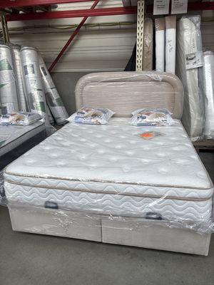 Ensemble matelas, sommier et tête de lit devant des matelas roulés sous emballage