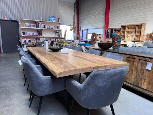 Grande table de repas en bois entourée de fauteuils de table en velours bleu