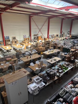 Vue d’ensemble de l’entrepôt Oli’Destock : tables, buffets et objets de décoration