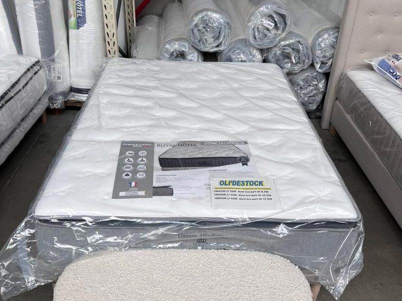 Rayon literie d’Oli’Destock : matelas exposé et matelas roulés sous emballage dans l’entrepôt